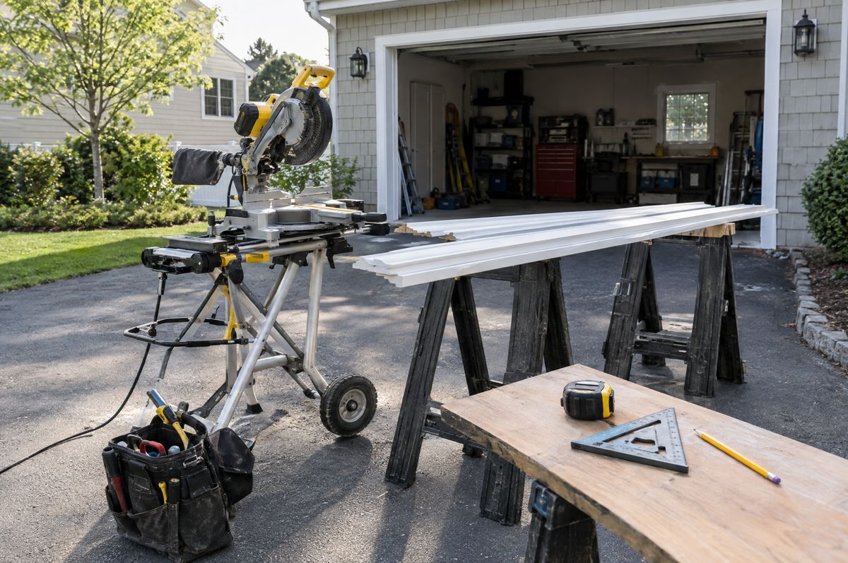 Tools, sheetrock sheets and a work table set up in a room under renovation