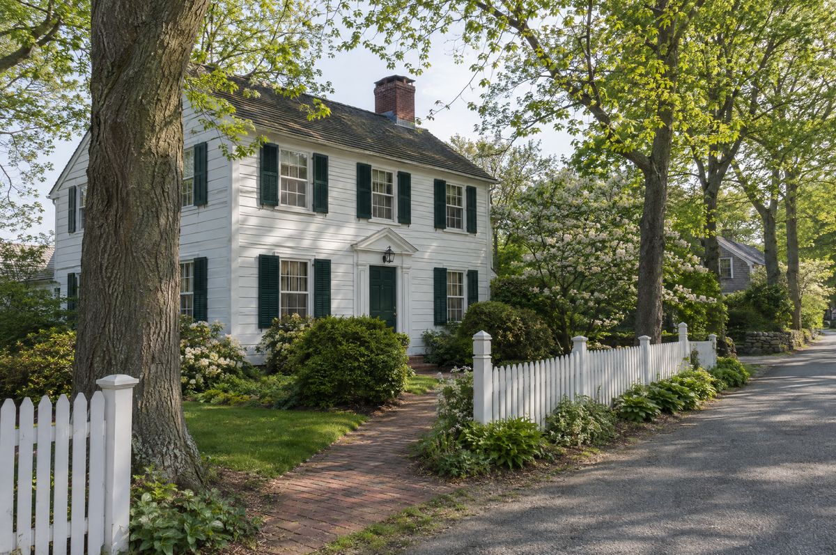 Historic white clapboard house with green shutters and a front porch