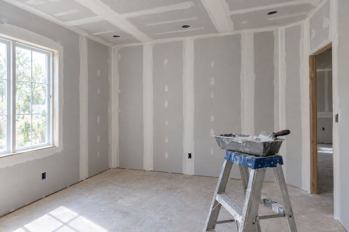 Room with new sheetrock walls and ceiling taped and finished, ready for primer