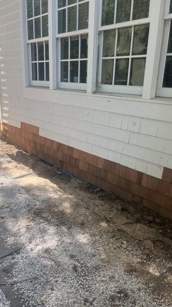 New cedar shingles installed below a row of windows