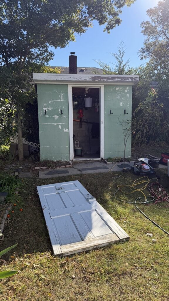 Old backyard shed with its worn door taken off before repairs